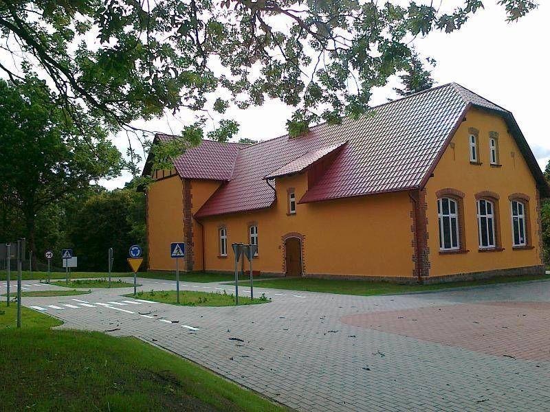 Pomarańczowy budynek z czerwonym dachem