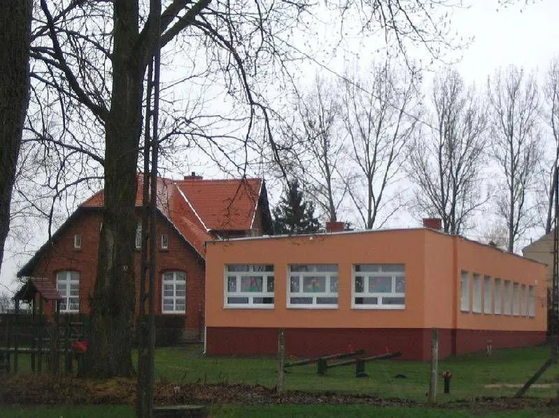 Pomarańczowy domek z czerwonym fundamentem